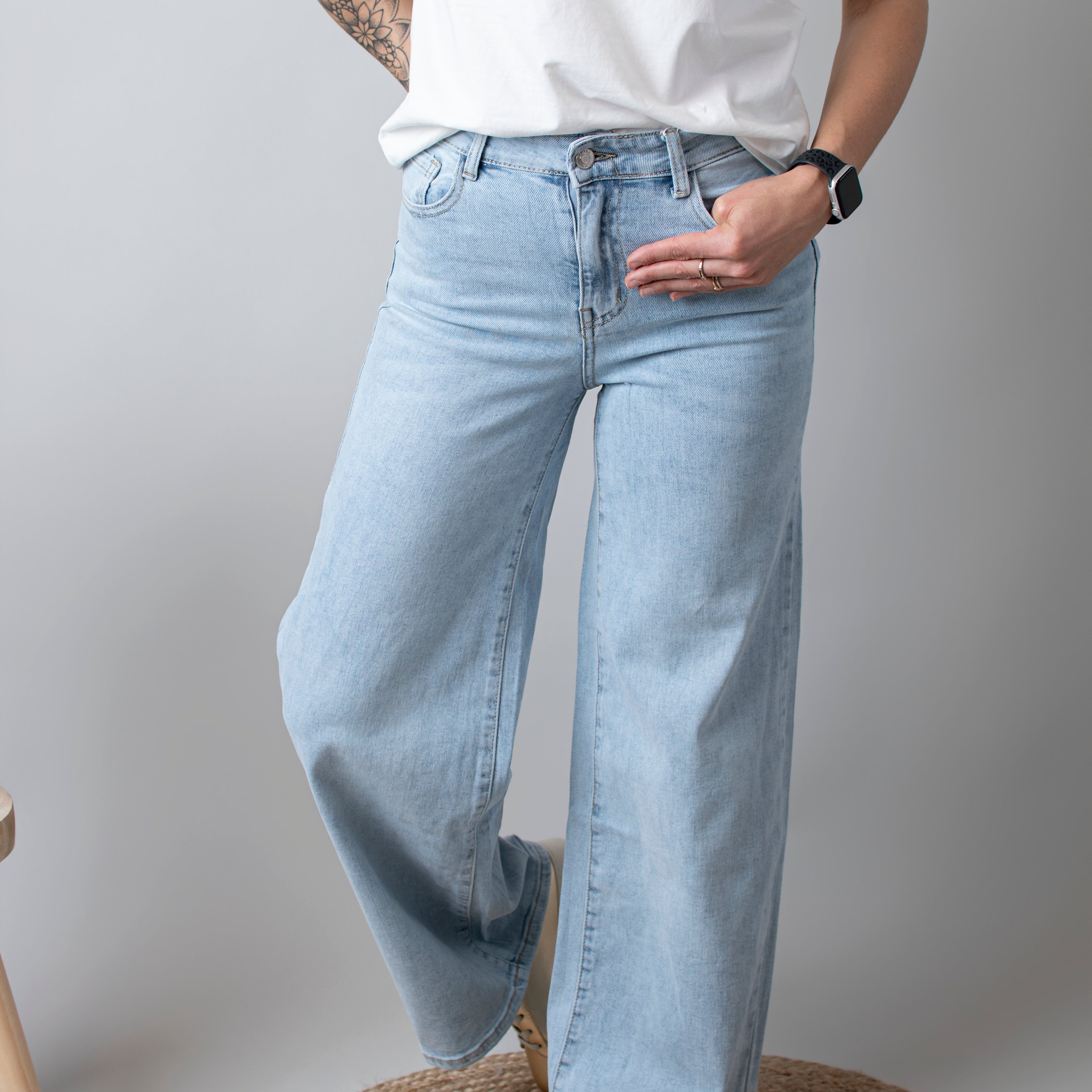 Jean Wide Leg bleu très clair en coton stretch, porté taille haute avec un haut ajusté et des bottes/baskets.
