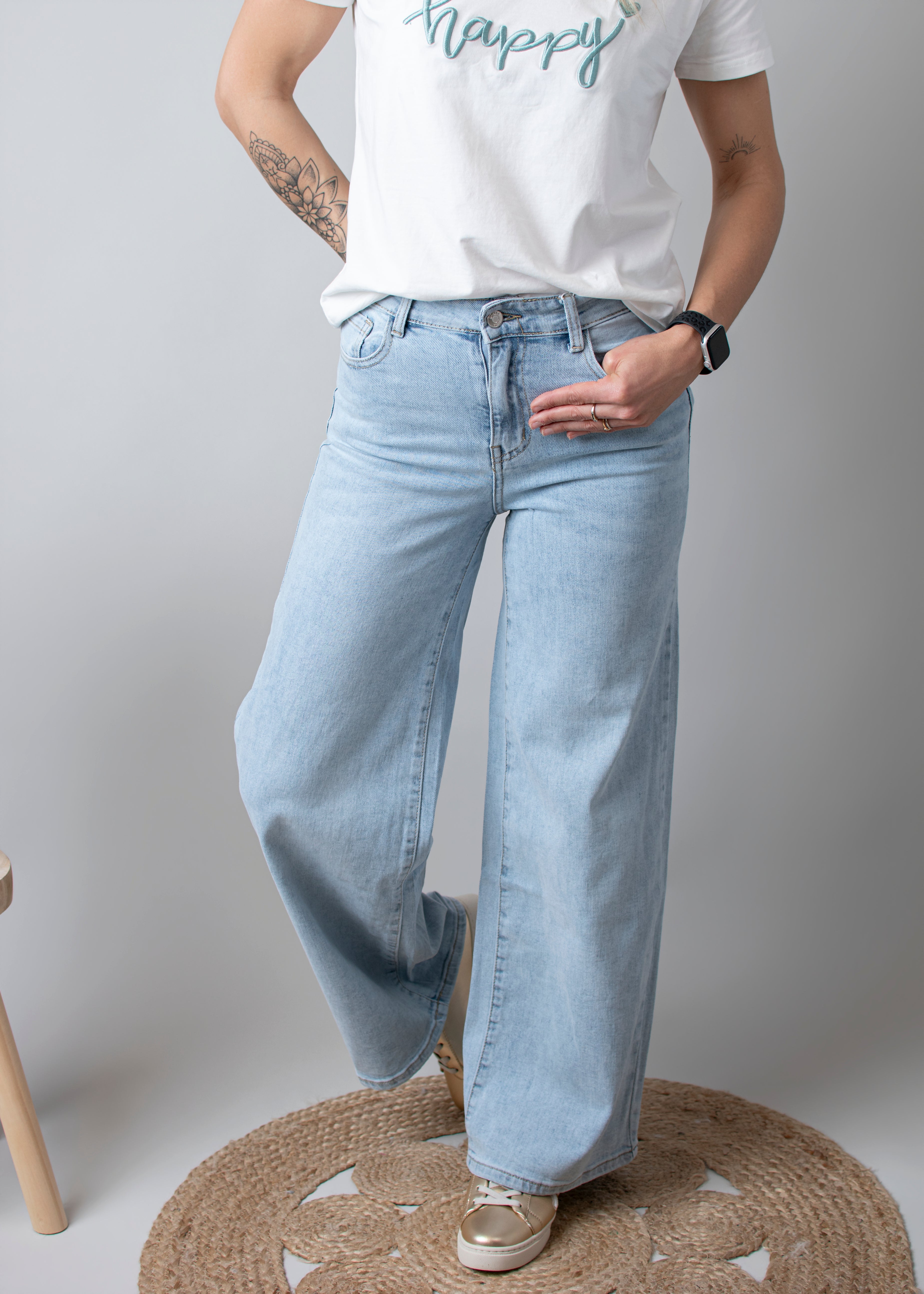 Jean Wide Leg bleu très clair en coton stretch, porté taille haute avec un haut ajusté et des bottes/baskets.