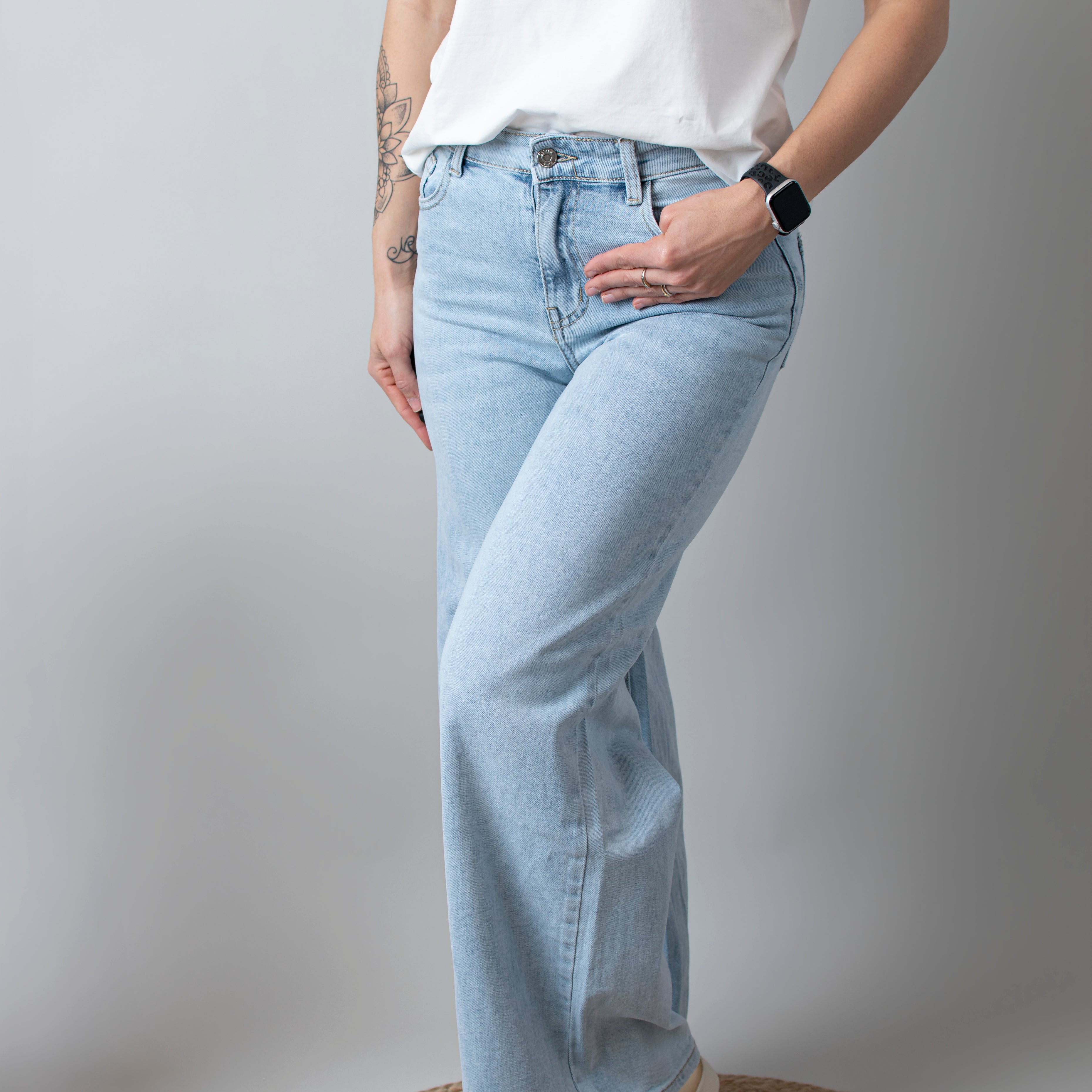 Jean Wide Leg bleu très clair en coton stretch, porté taille haute avec un haut ajusté et des bottes/baskets.