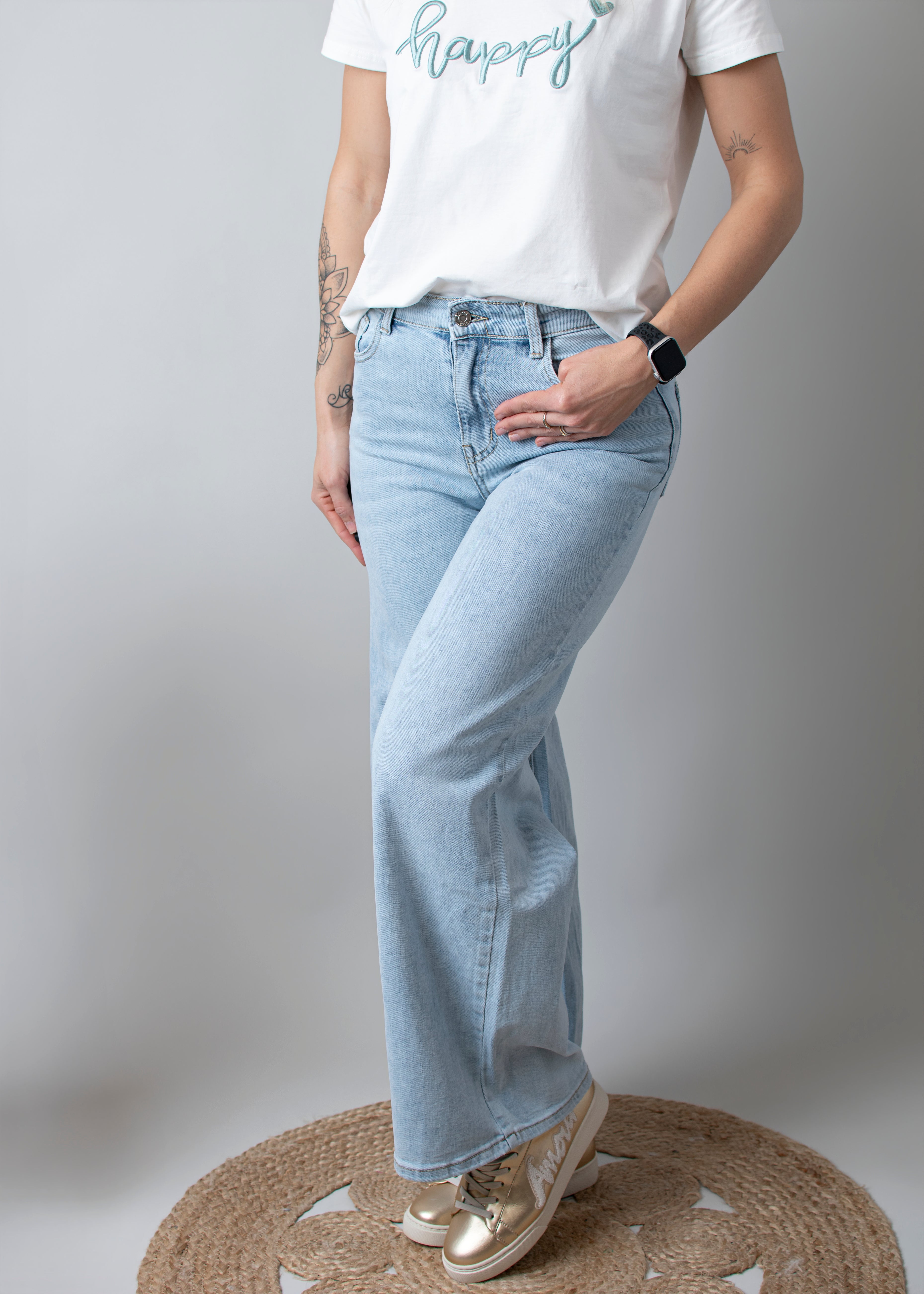 Jean Wide Leg bleu très clair en coton stretch, porté taille haute avec un haut ajusté et des bottes/baskets.