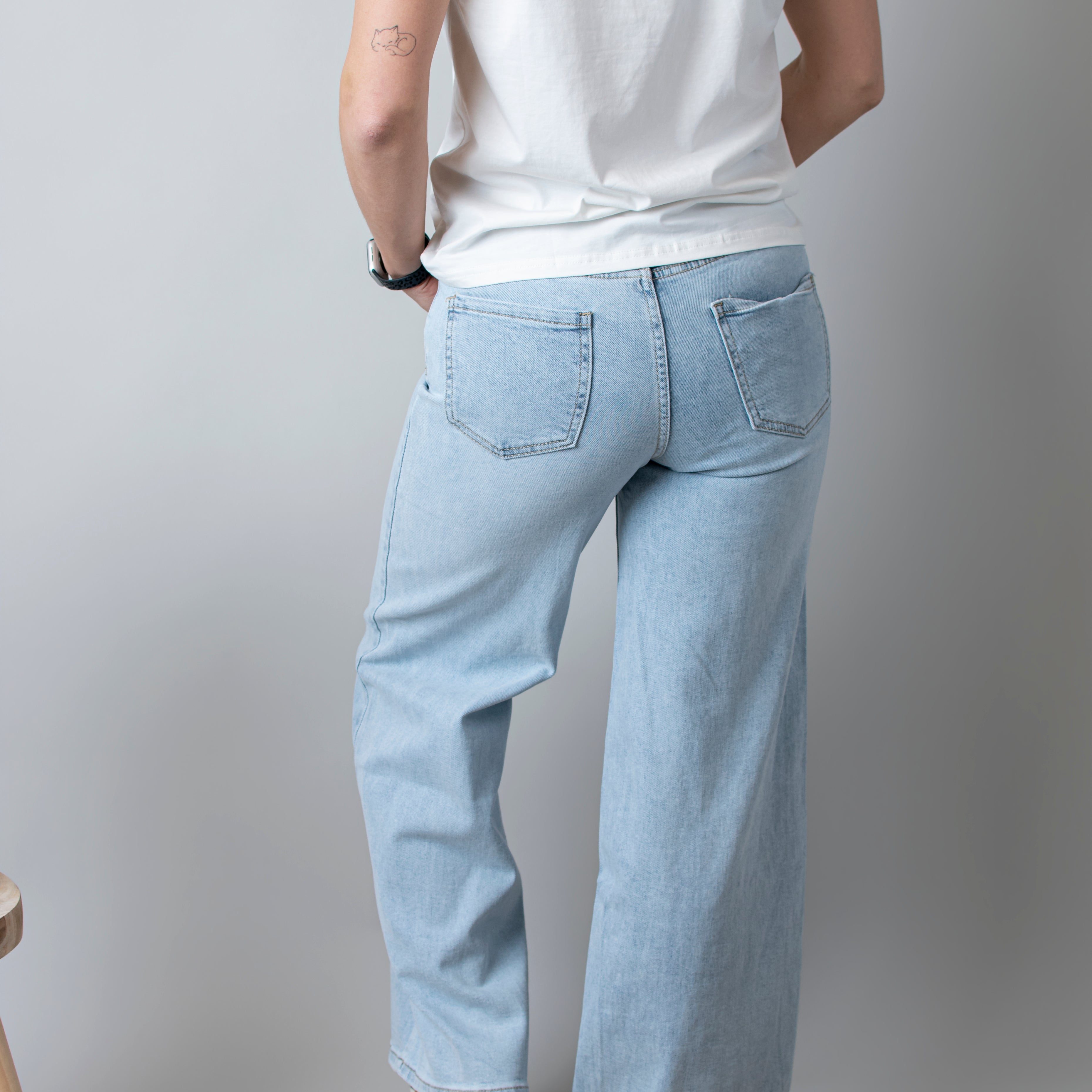 Jean Wide Leg bleu très clair en coton stretch, porté taille haute avec un haut ajusté et des bottes/baskets.