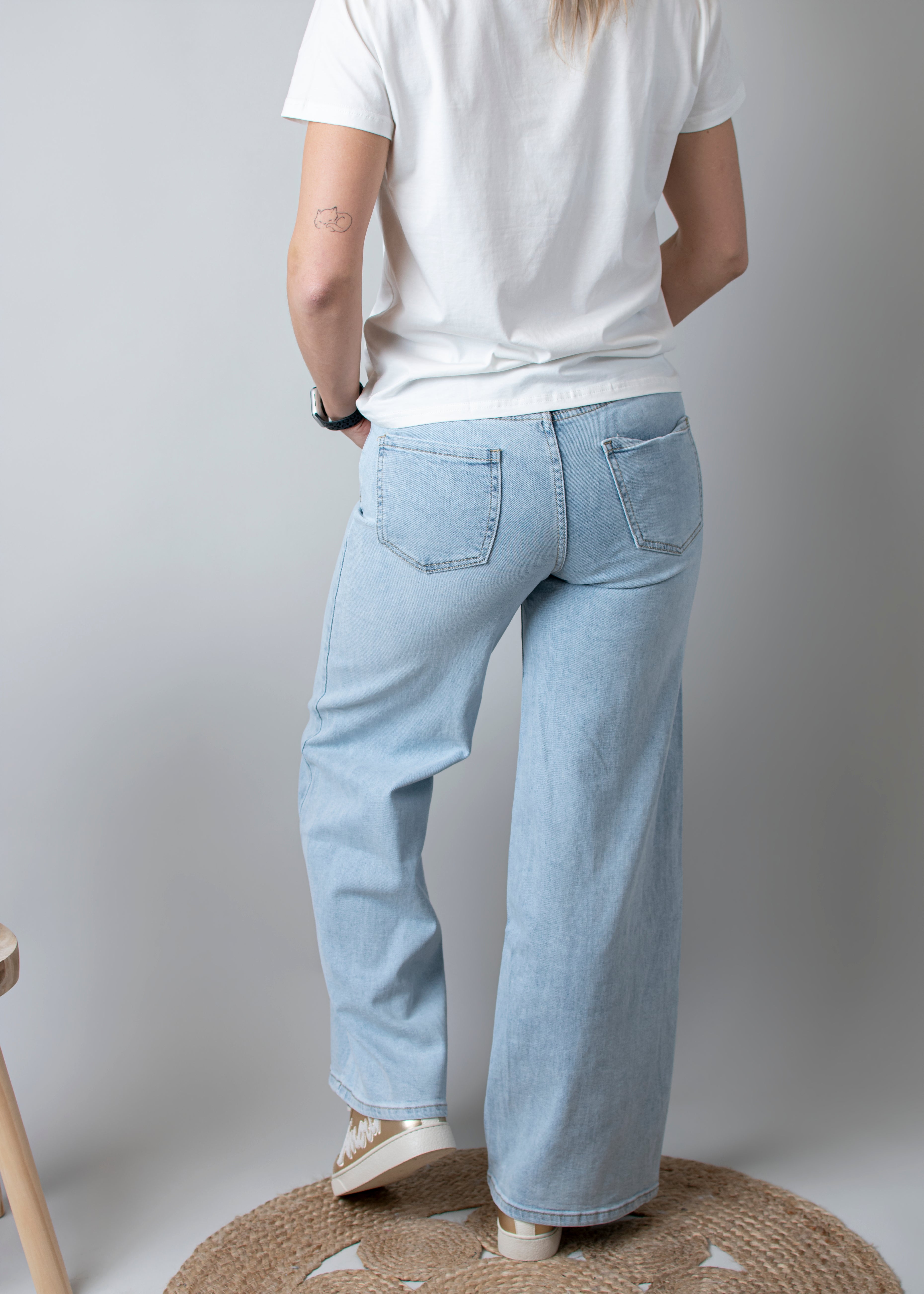 Jean Wide Leg bleu très clair en coton stretch, porté taille haute avec un haut ajusté et des bottes/baskets.