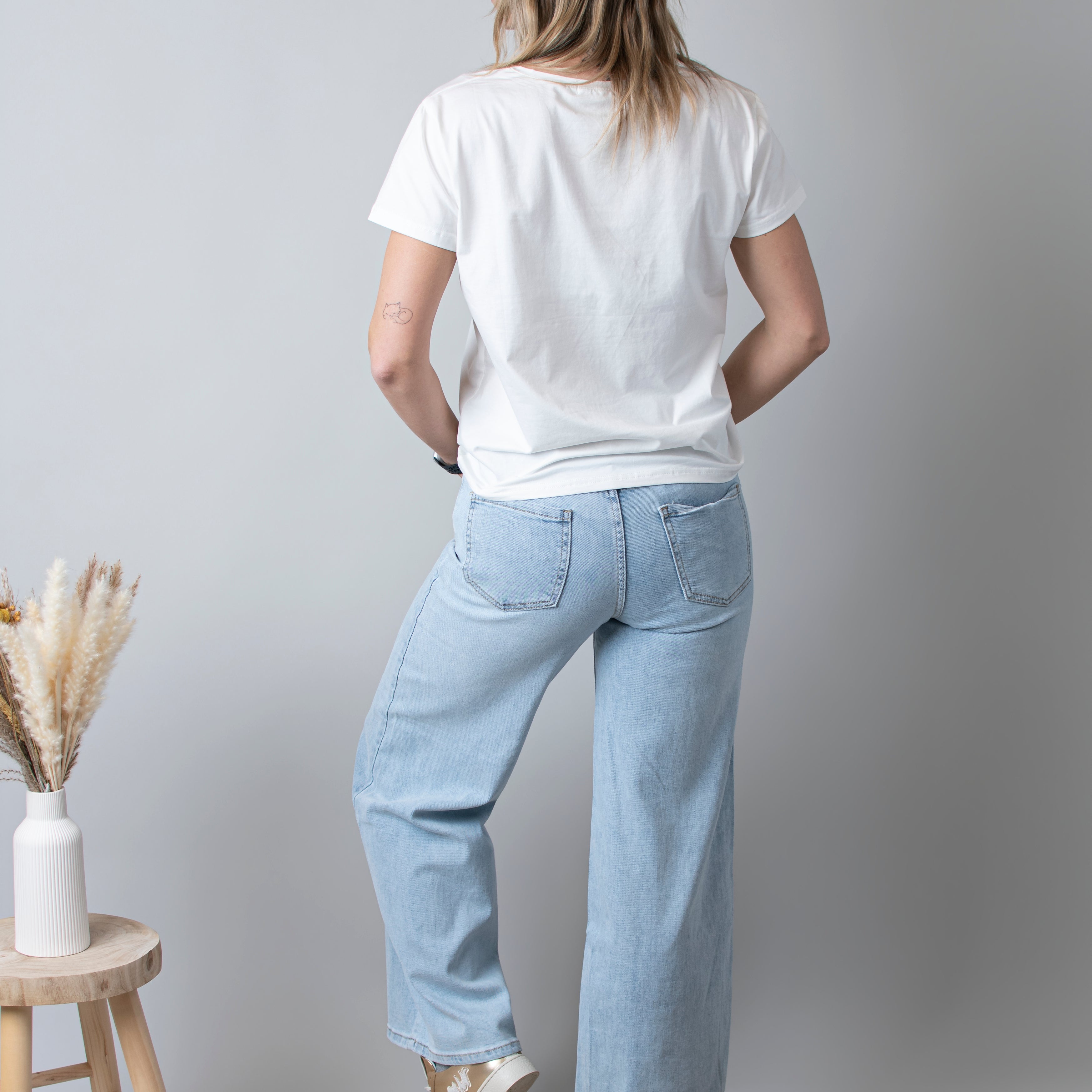 Jean Wide Leg bleu très clair en coton stretch, porté taille haute avec un haut ajusté et des bottes/baskets.