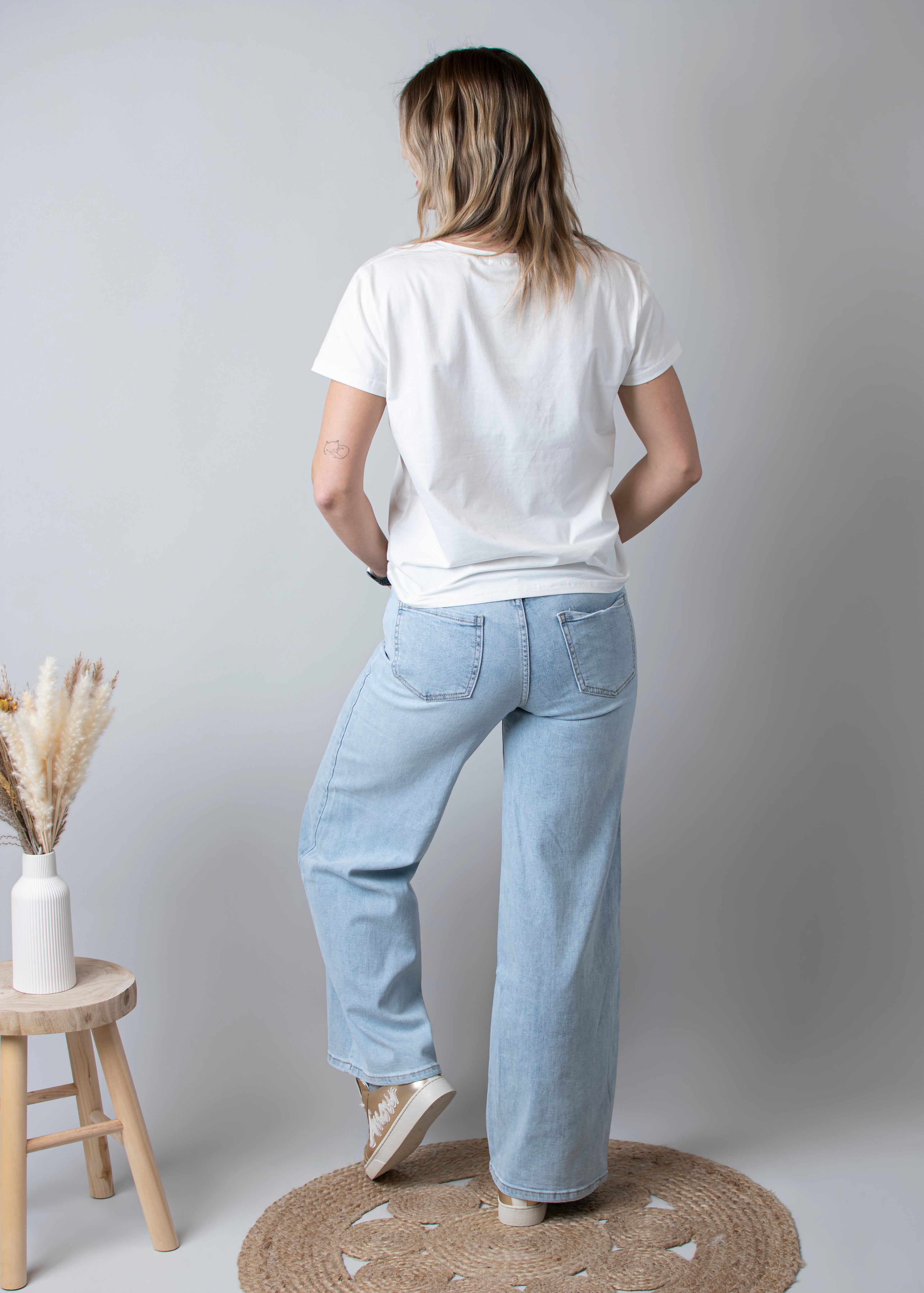 Jean Wide Leg bleu très clair en coton stretch, porté taille haute avec un haut ajusté et des bottes/baskets.