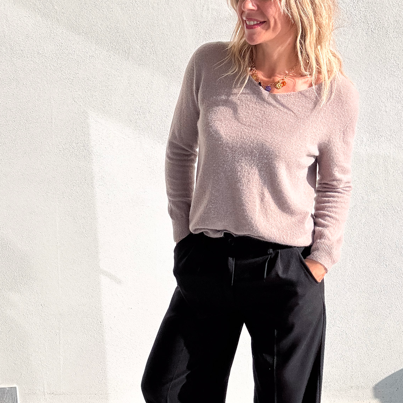 Pantalon large noir taille haute, coupe fluide, porté avec un pull taupe et des baskets blanches, look confortable et élégant.