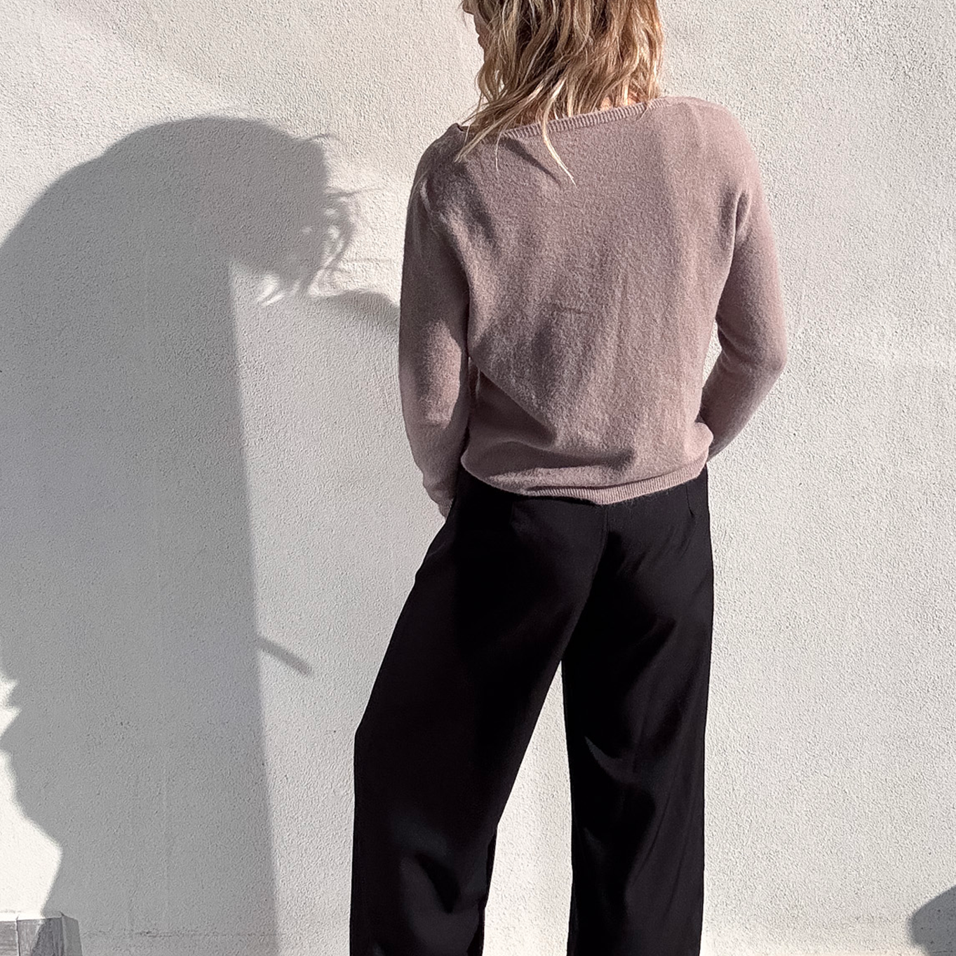 Pantalon large noir taille haute, coupe fluide, porté avec un pull taupe et des baskets blanches, look confortable et élégant.