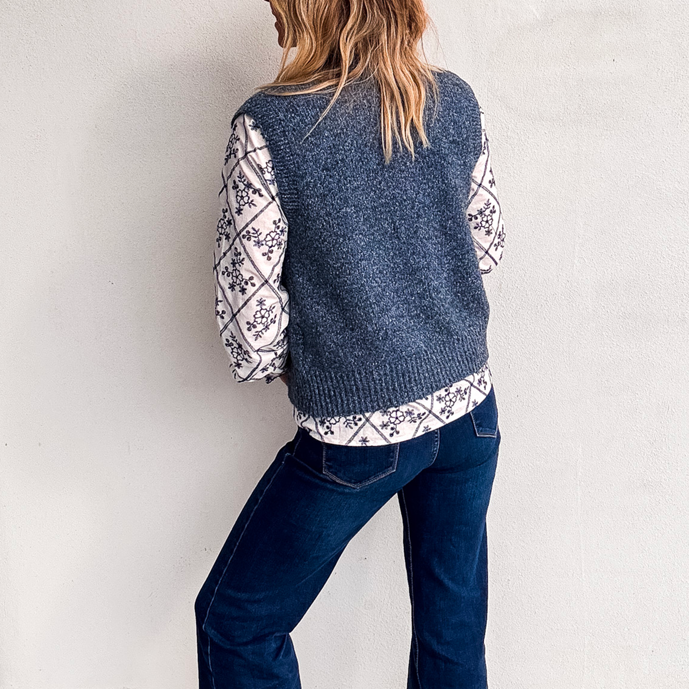 Gilet sans manches zippé bleu chiné en maille, gros plan sur le col et la texture.