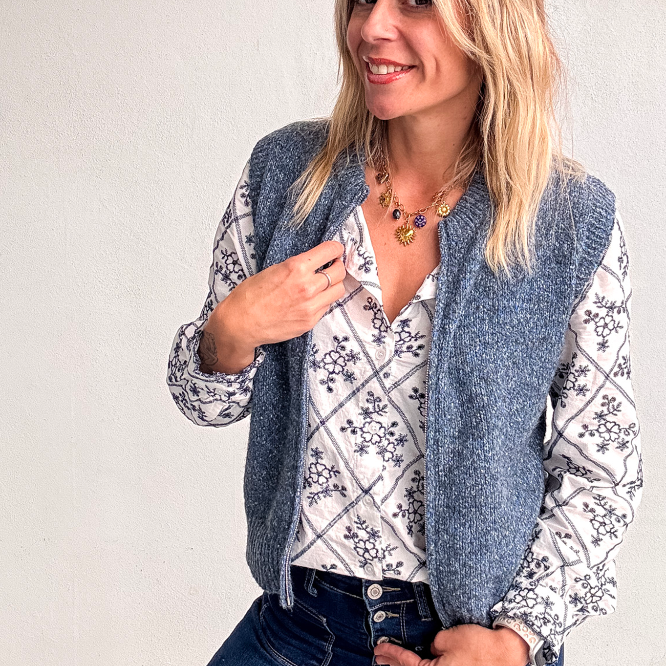 Gilet sans manches zippé bleu chiné en maille, gros plan sur le col et la texture.