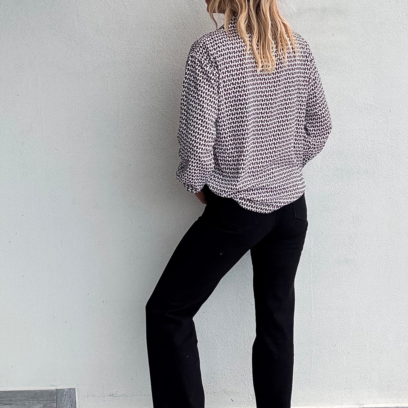 Chemise motif pied-de-poule noir et blanc, boutons noirs, et collier multicharmes