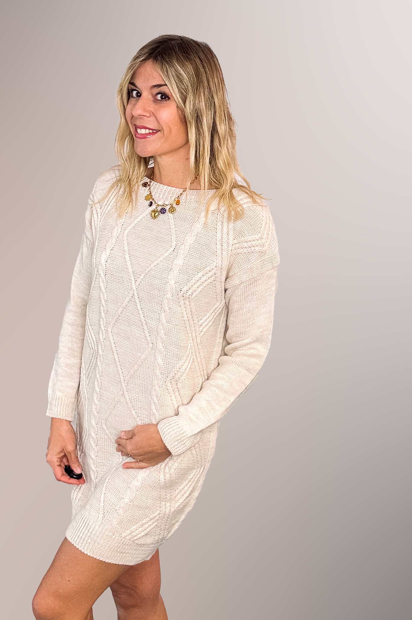 Robe pull courte torsadée couleur écru, portée avec des bottines claires, style d'hiver chic