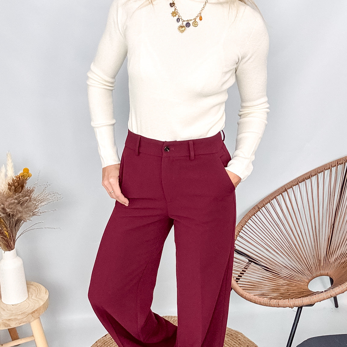 Pull fin beige col rond en maille douce, coupe droite, porté rentré dans un pantalon foncé.