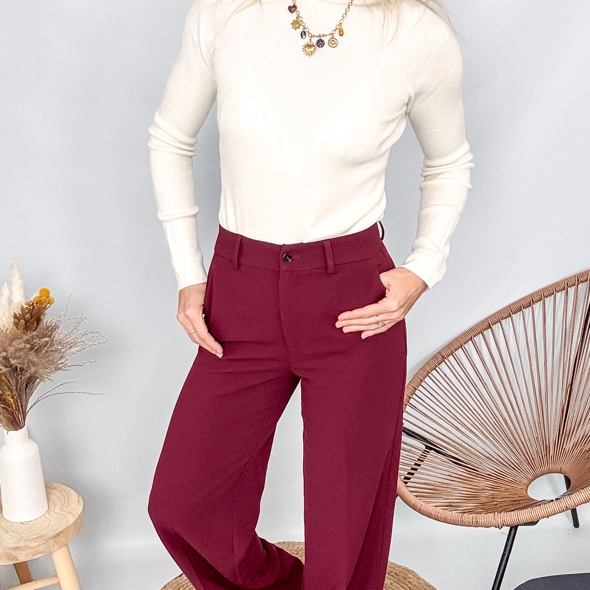 Pull fin beige col rond en maille douce, coupe droite, porté rentré dans un pantalon foncé.