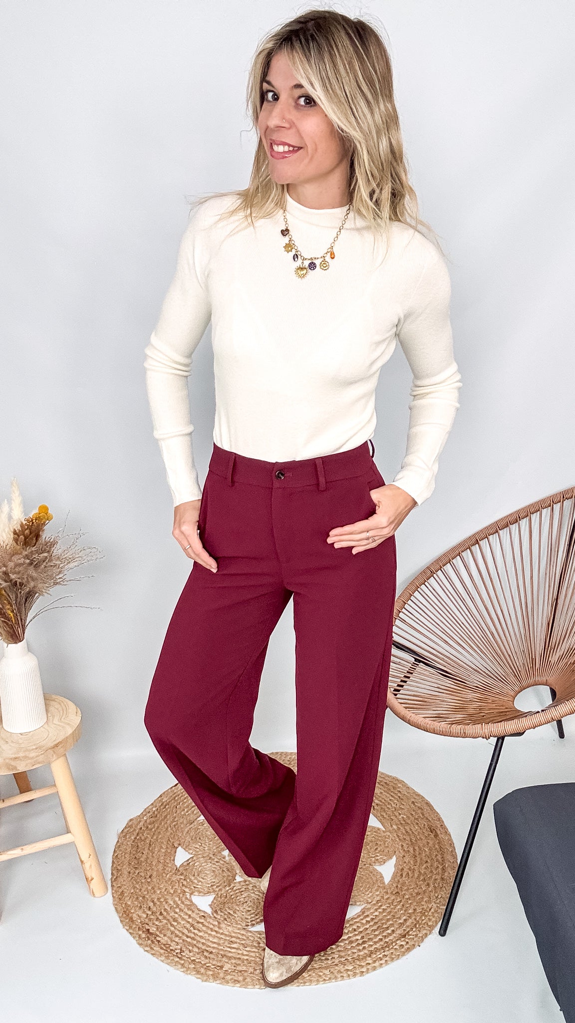 Pull fin beige col rond en maille douce, coupe droite, porté rentré dans un pantalon foncé.