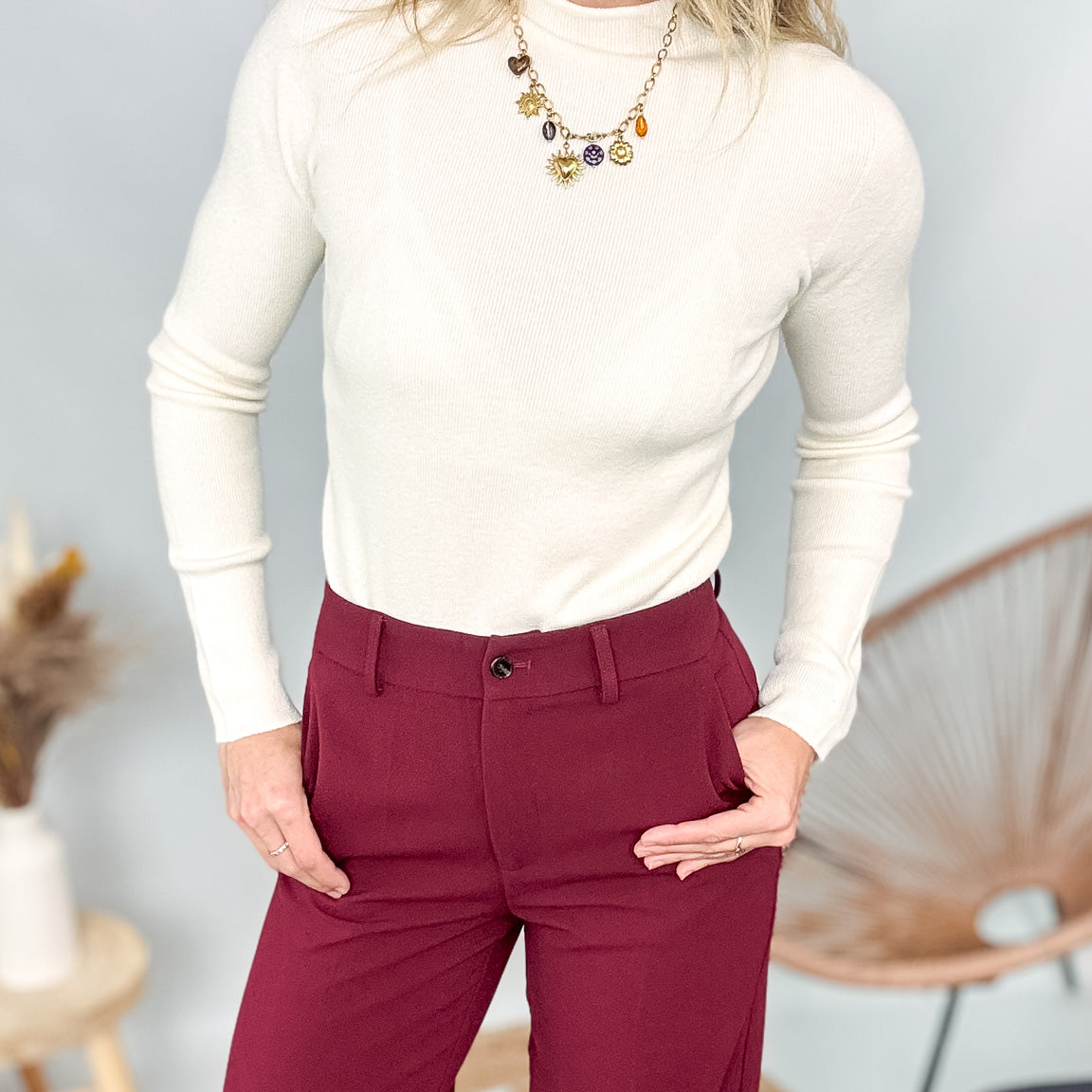 Pull fin beige col rond en maille douce, coupe droite, porté rentré dans un pantalon foncé.