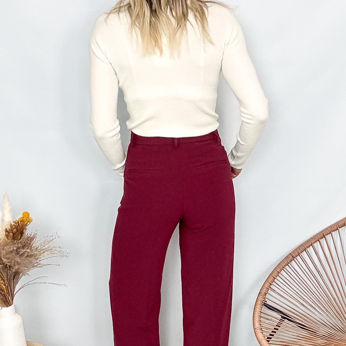 Pantalon tailleur femme bordeaux fluide, coupe droite, porté avec un pull rentré.
