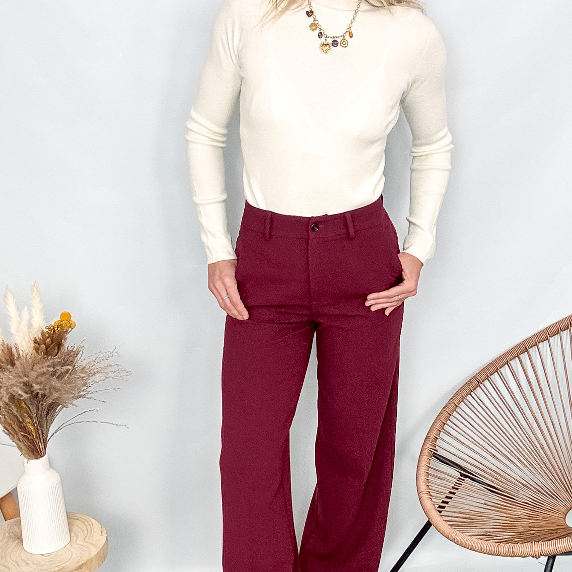Pantalon tailleur femme bordeaux fluide, coupe droite, porté avec un pull rentré.
