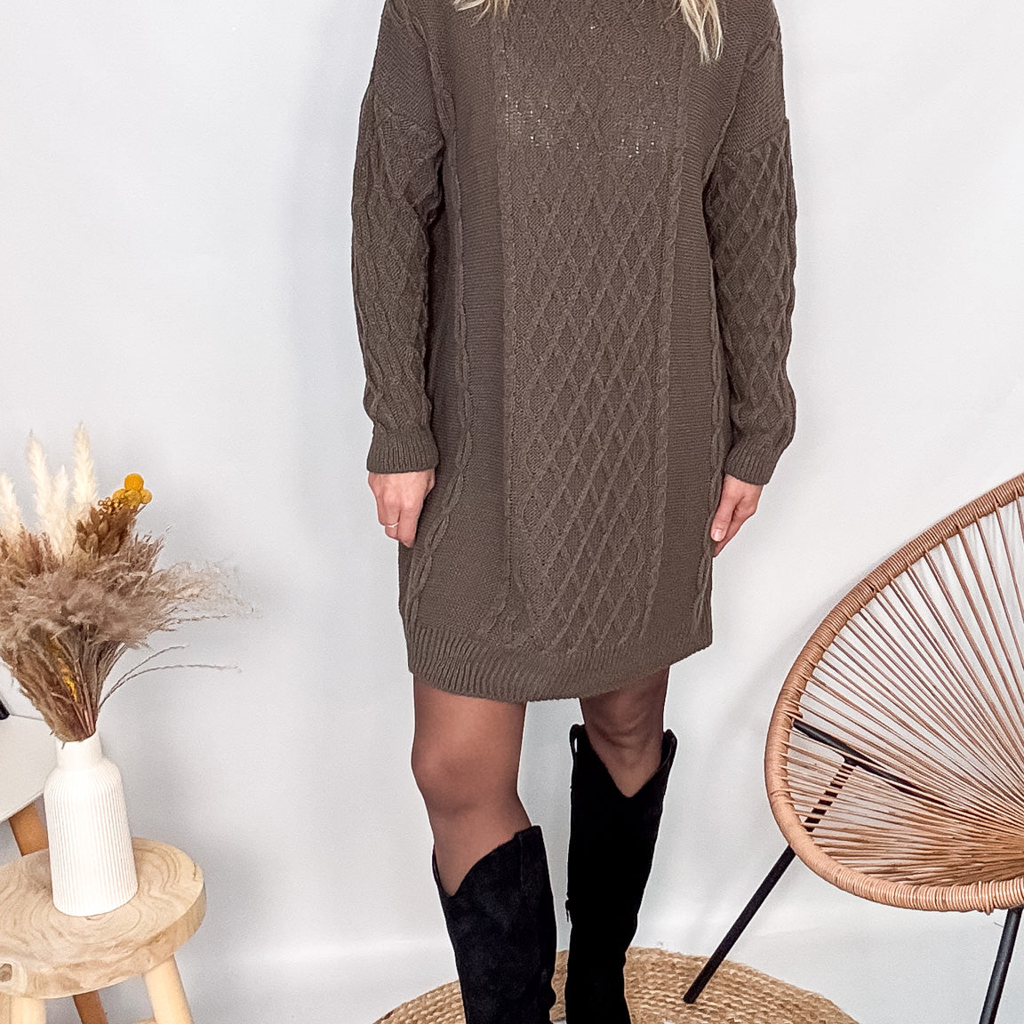 Robe pull maille 100% acrylique couleur marron, coupe droite, portée avec des bottes d'hiver.