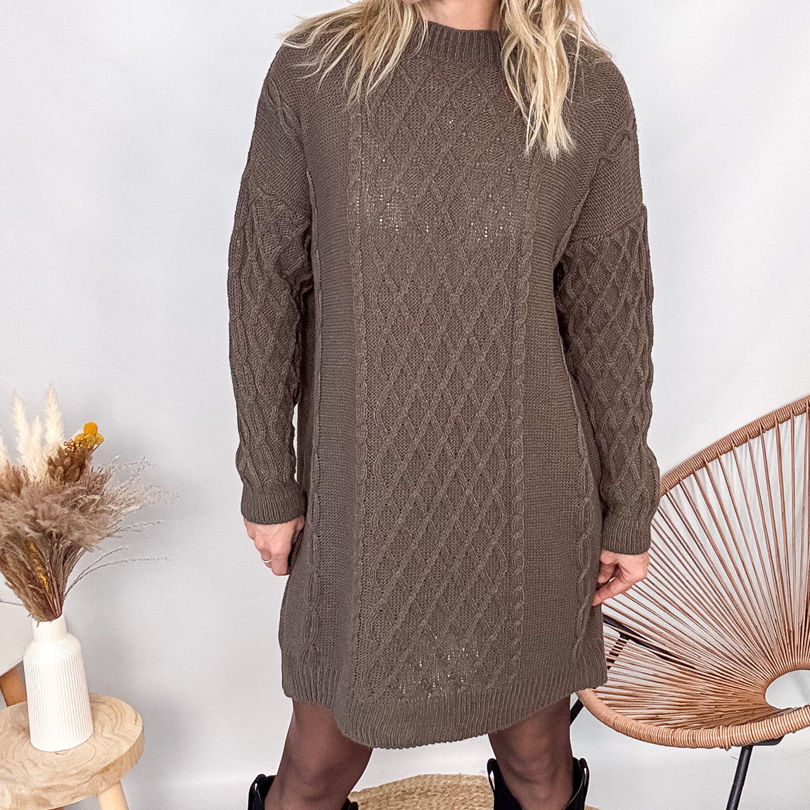 Robe pull maille 100% acrylique couleur marron, coupe droite, portée avec des bottes d'hiver.