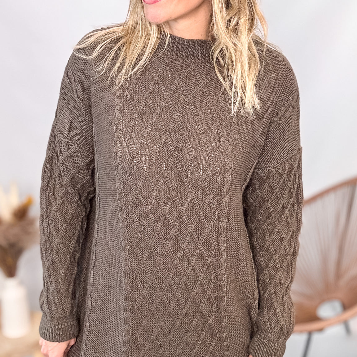 Robe pull maille 100% acrylique couleur marron, coupe droite, portée avec des bottes d'hiver.