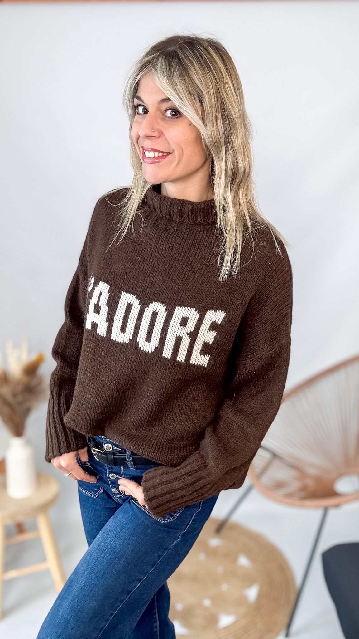 Pull marron col roulé maille, fabriqué en Italie, porté rentré dans un pantalon foncé.