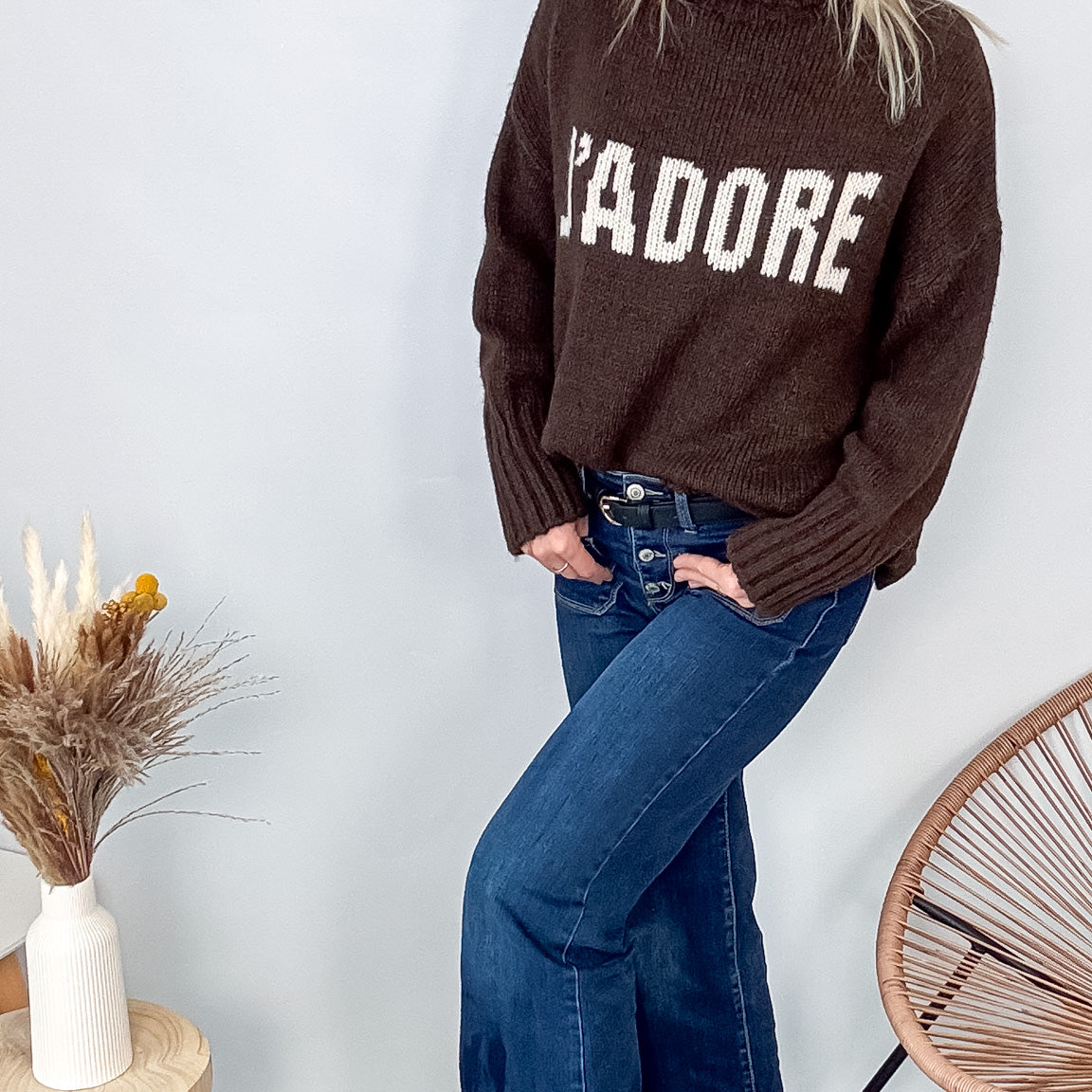 Pull marron col roulé maille, fabriqué en Italie, porté rentré dans un pantalon foncé.