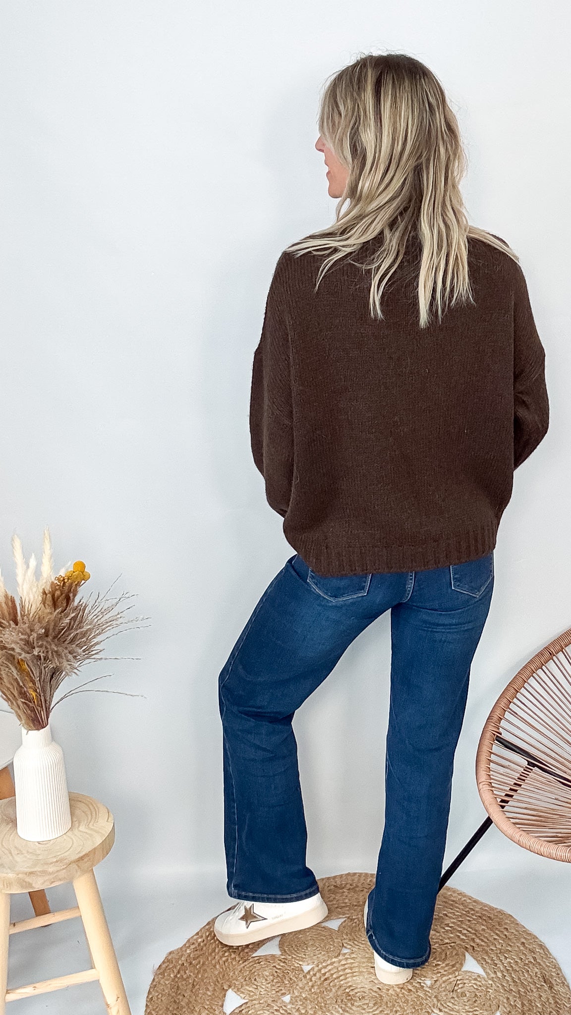 Pull marron col roulé maille, fabriqué en Italie, porté rentré dans un pantalon foncé.