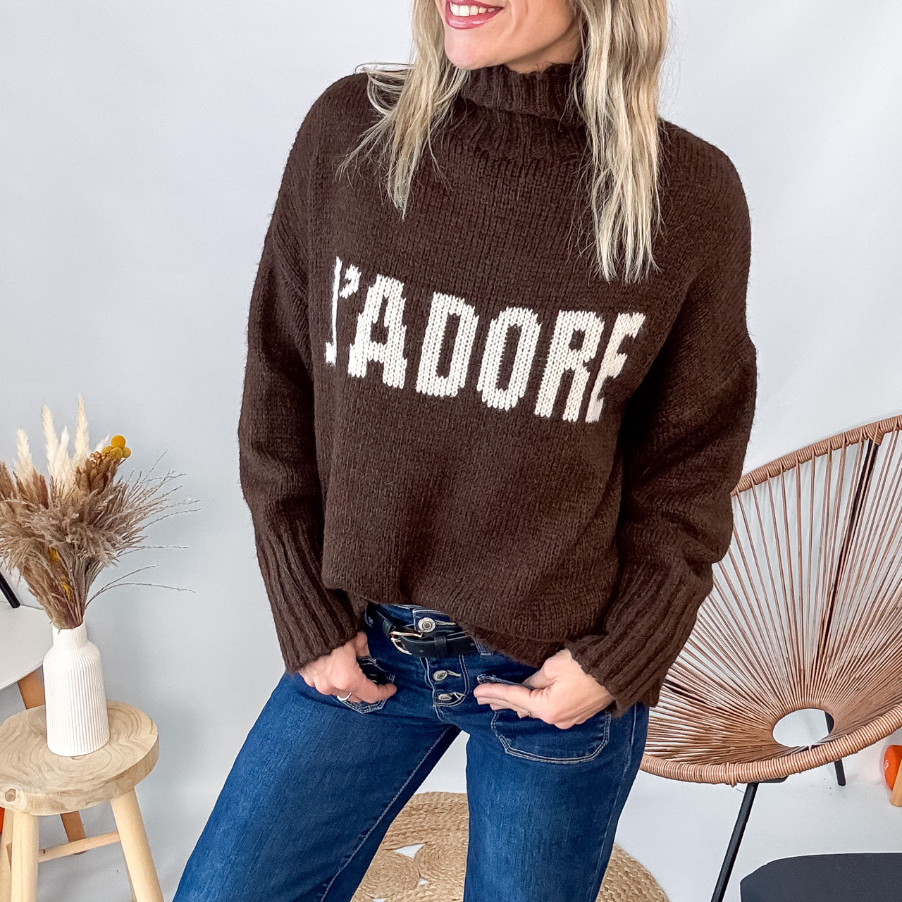 Pull marron col roulé maille, fabriqué en Italie, porté rentré dans un pantalon foncé.