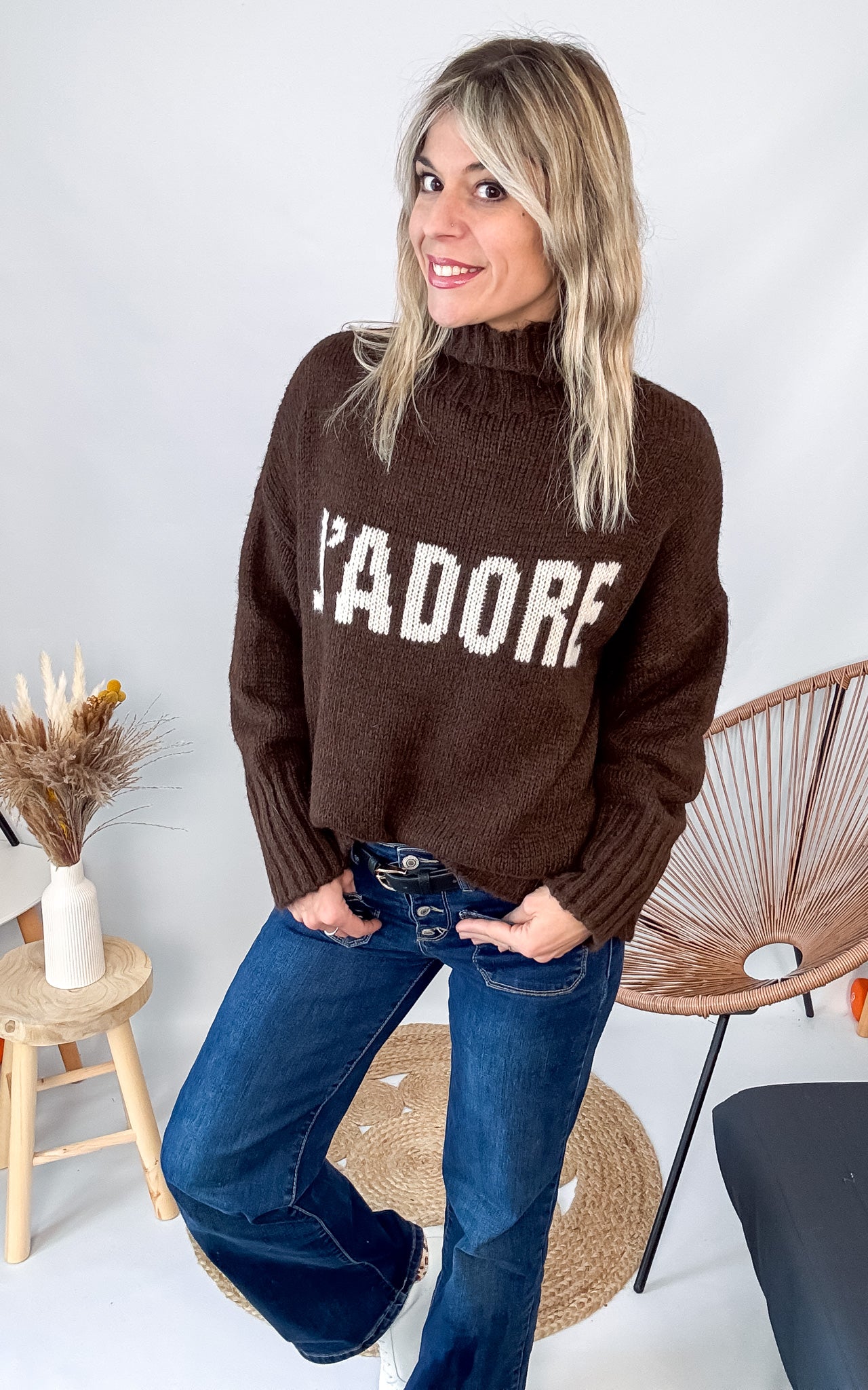 Pull marron col roulé maille, fabriqué en Italie, porté rentré dans un pantalon foncé.