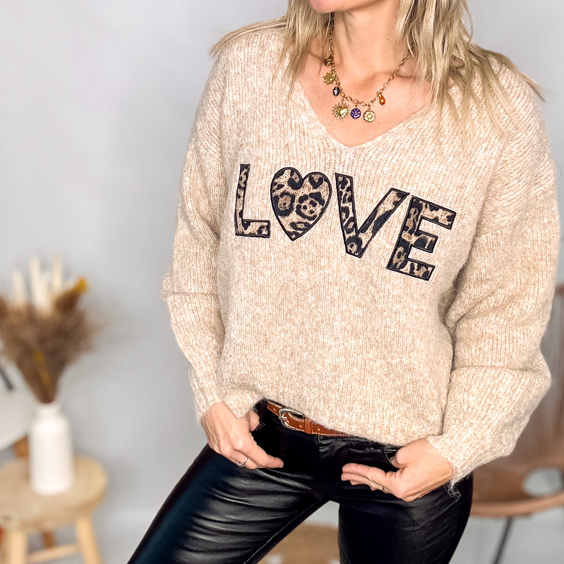 Pull oversize col V beige/taupe en maille douce (laine), porté rentré avec un pantalon foncé