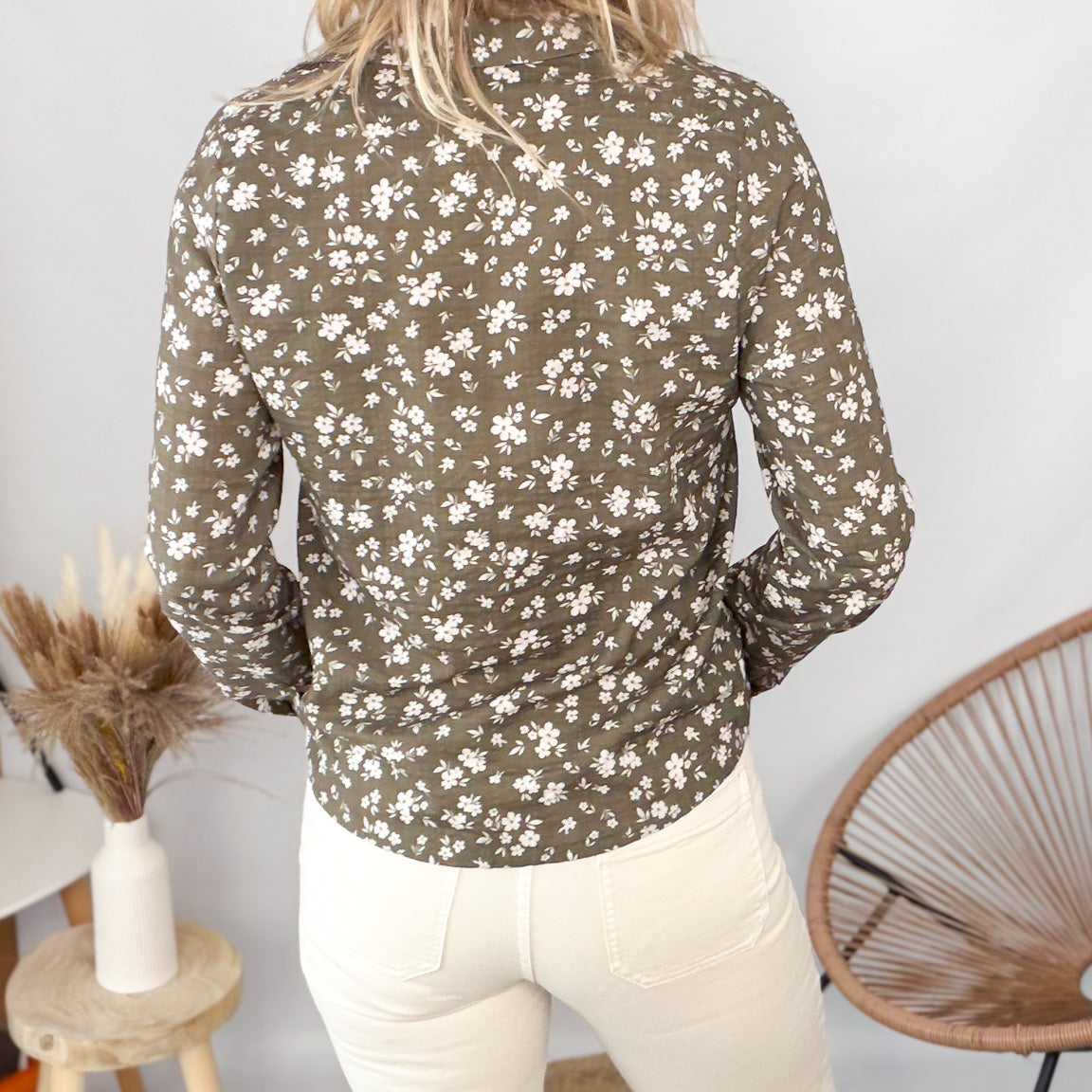 Femme portant une chemise kaki à fleurs blanches et un pantalon blanc - La Boutique de Lydie.