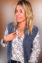 Gilet sans manches zippé bleu chiné en maille, gros plan sur le col et la texture.