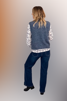 Gilet sans manches zippé bleu chiné en maille, gros plan sur le col et la texture.