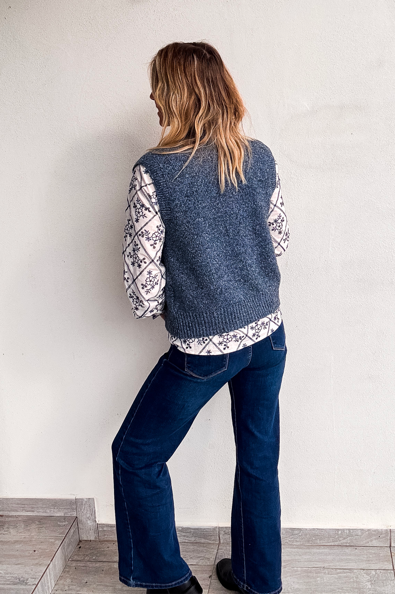 Gilet sans manches zippé bleu chiné en maille, gros plan sur le col et la texture.