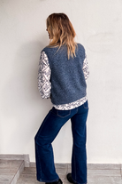 Gilet sans manches zippé bleu chiné en maille, gros plan sur le col et la texture.