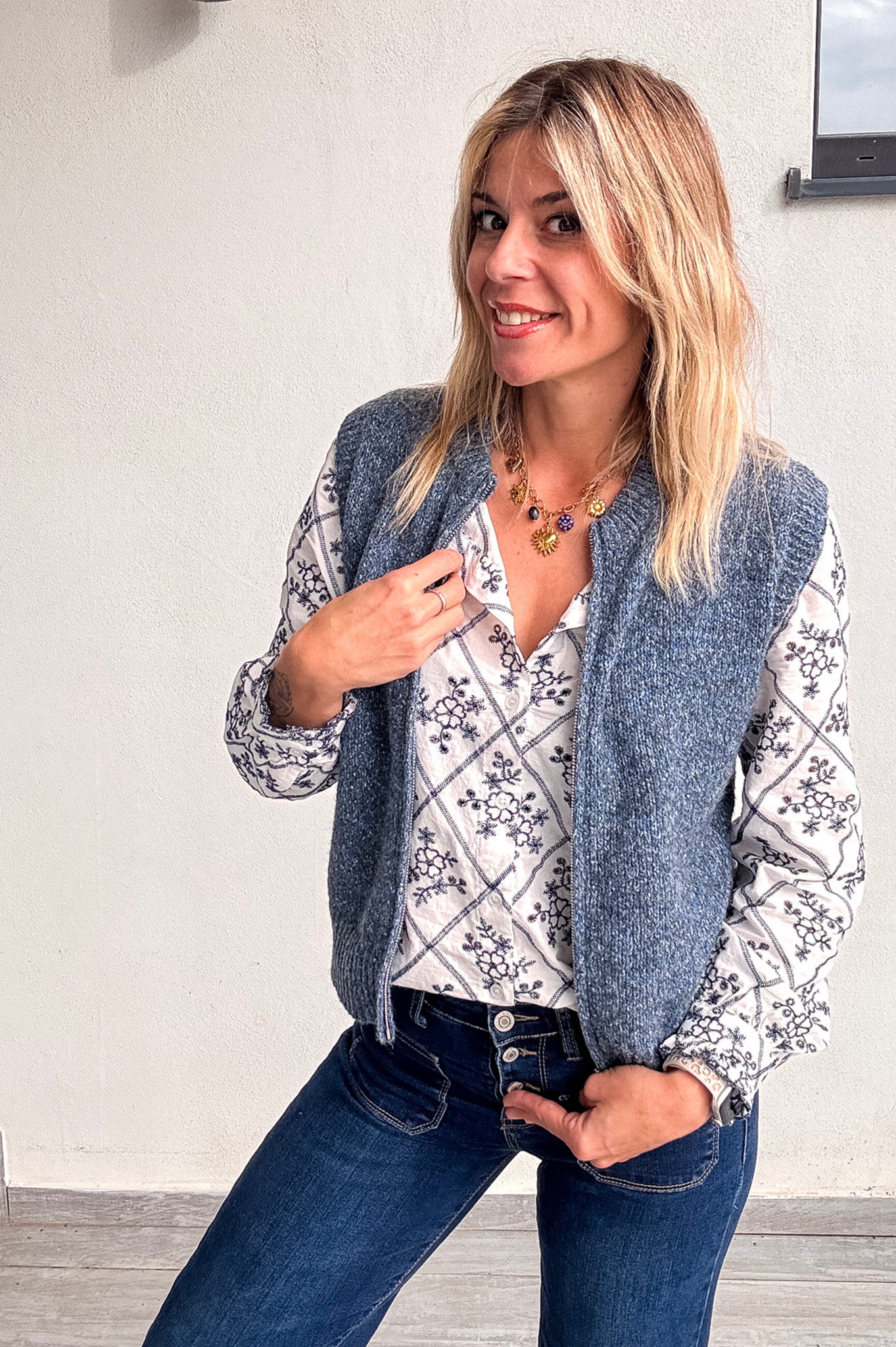 Gilet sans manches zippé bleu chiné en maille, gros plan sur le col et la texture.