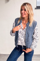 Gilet sans manches zippé bleu chiné en maille, gros plan sur le col et la texture.