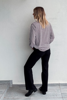 Chemise motif pied-de-poule noir et blanc, boutons noirs, et collier multicharmes