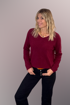 Pull bordeaux col V en maille douce, Taille Unique, porté rentré dans un jean noir taille haute avec une ceinture camel