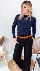 Pull fin bleu marine col rond en maille douce (viscose/acrylique), porté rentré dans un pantalon foncé