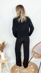 Pull noir court (crop) en maille douce, longueur 49 cm, porté avec un jean taille haute.