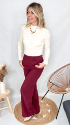 Pantalon tailleur femme bordeaux fluide, coupe droite, porté avec un pull rentré.