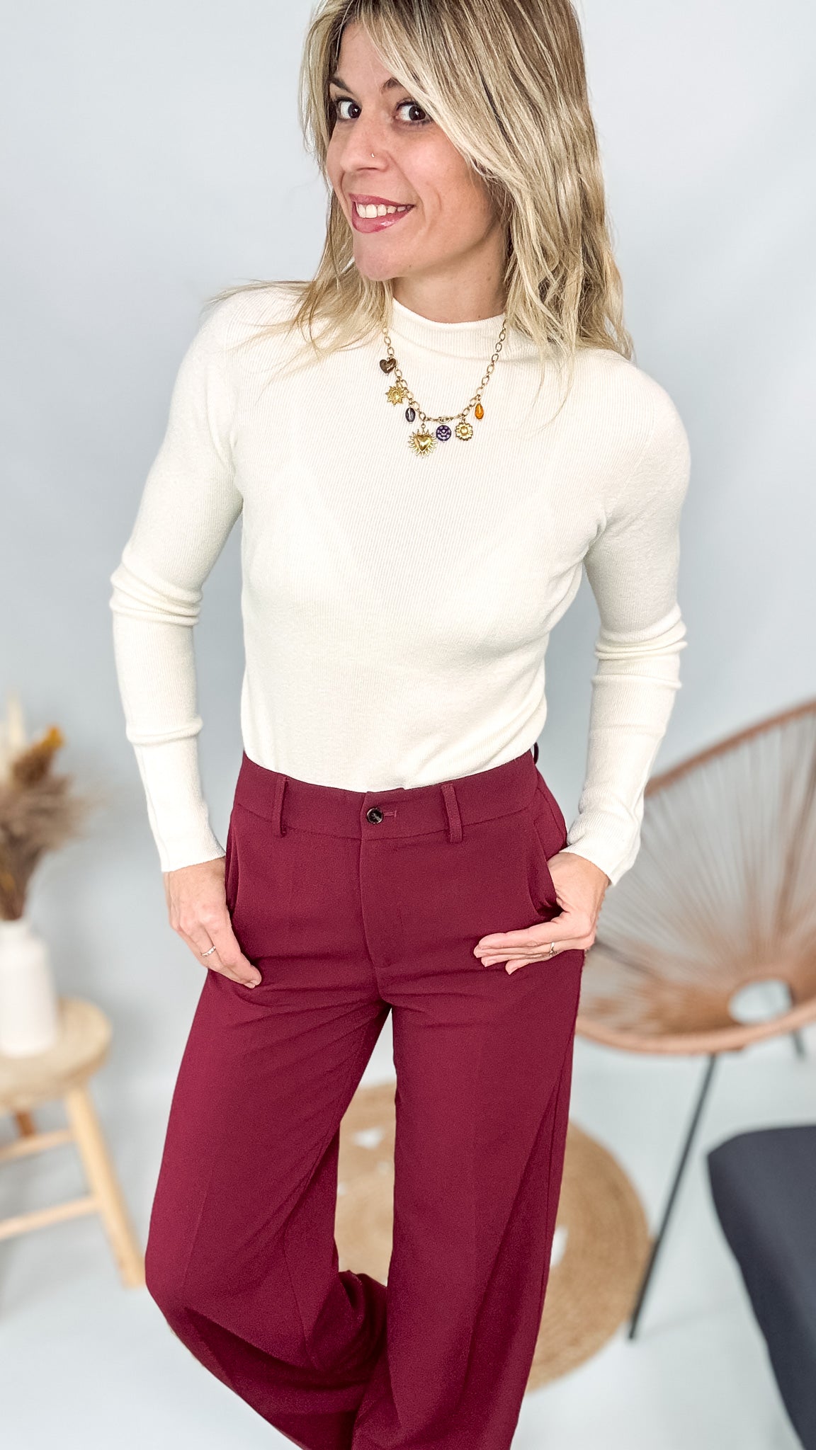 Pull fin beige col rond en maille douce, coupe droite, porté rentré dans un pantalon foncé.