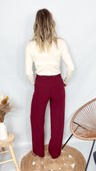 Pantalon tailleur femme bordeaux fluide, coupe droite, porté avec un pull rentré.