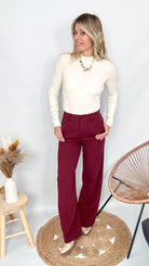 Pantalon tailleur femme bordeaux fluide, coupe droite, porté avec un pull rentré.