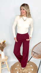 Pantalon tailleur femme bordeaux fluide, coupe droite, porté avec un pull rentré.