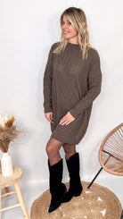 Robe pull maille 100% acrylique couleur marron, coupe droite, portée avec des bottes d'hiver.