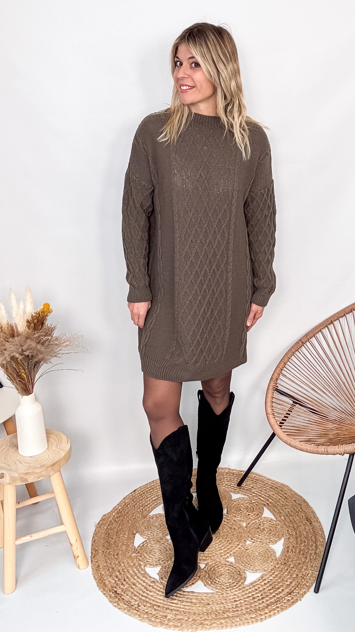 Robe pull maille 100% acrylique couleur marron, coupe droite, portée avec des bottes d'hiver.
