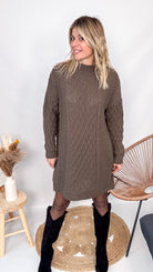 Robe pull maille 100% acrylique couleur marron, coupe droite, portée avec des bottes d'hiver.