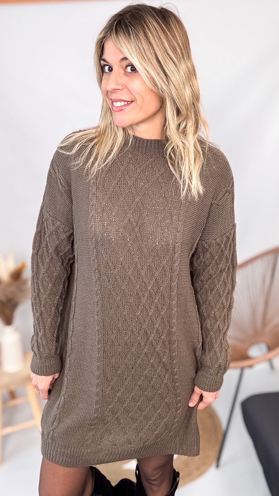 Robe pull maille 100% acrylique couleur marron, coupe droite, portée avec des bottes d'hiver.