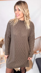 Robe pull maille 100% acrylique couleur marron, coupe droite, portée avec des bottes d'hiver.